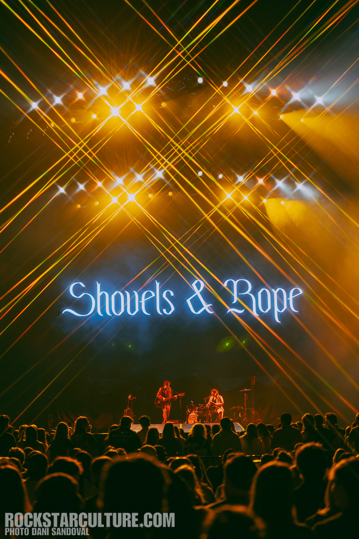 A live concert performance by Shovels & Rope with vibrant stage lights and an enthusiastic audience.