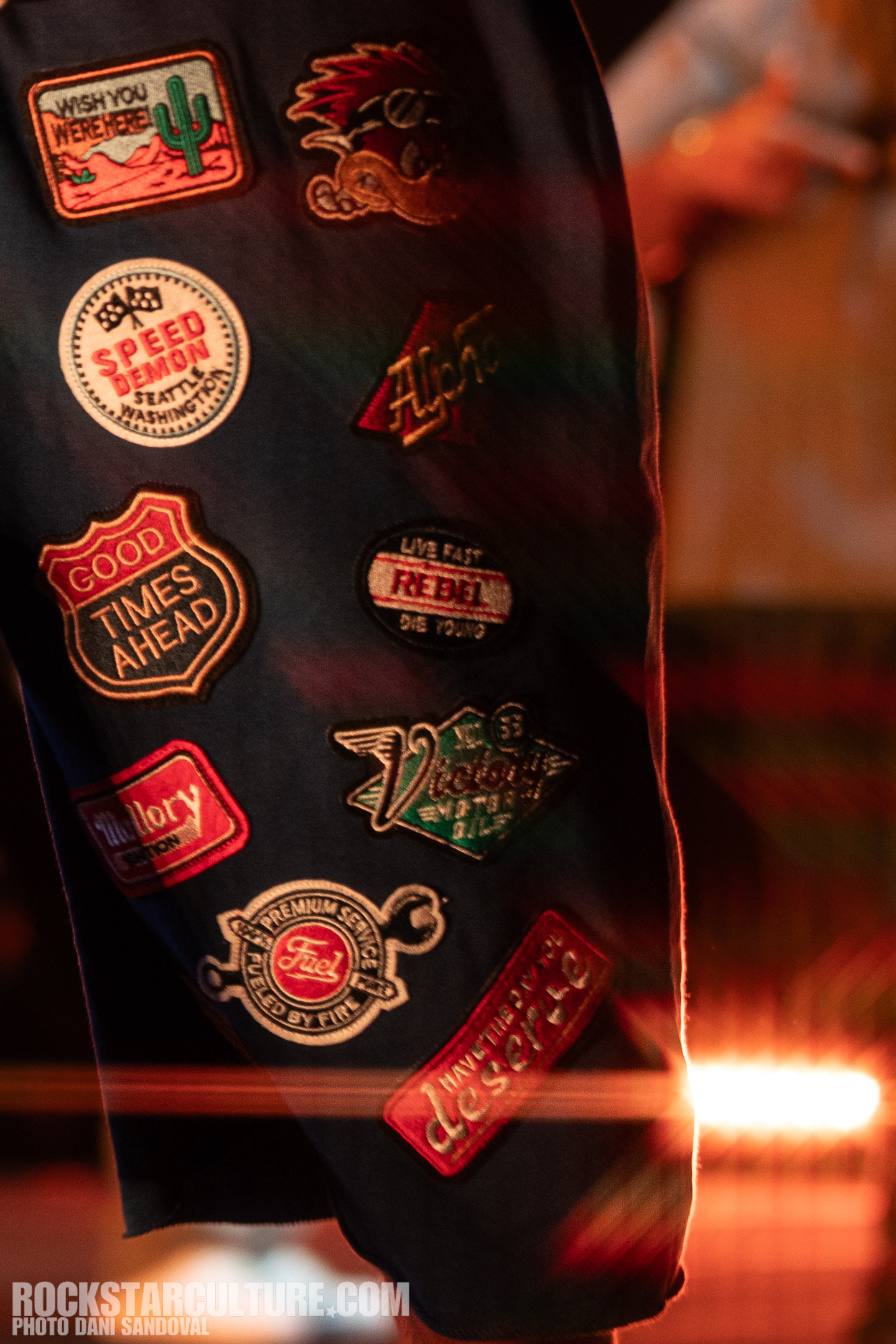 Close-up of a collection of colorful embroidered patches on clothing featuring various designs and slogans.